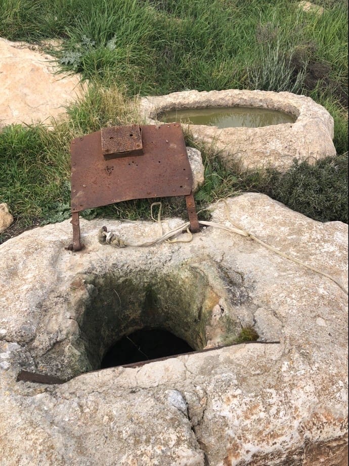 Rock well in the mountains nearJerusalem. Beside it is the stone trough that the local shepherds still use to water their flocks. Even though it has a rusty iron lid now, in ancient times it would have been covered by a rock. Photo by John Buckner